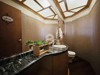 Foto de um banheiro com bancada de mármore e piso claro.