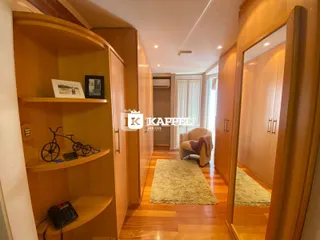 Hall de entrada com armários de madeira e piso de madeira polida.