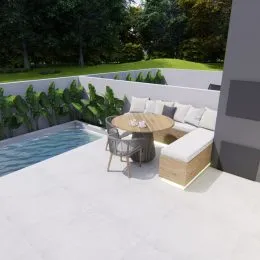 Varanda externa com mesa redonda e assentos em um espaço aberto.