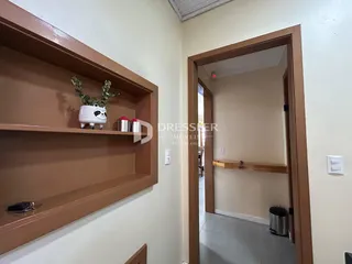 A foto mostra um corredor interno com prateleiras de madeira.