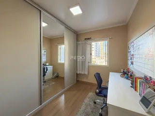 Vista interna de um ambiente com piso de madeira e espelho refletindo outra sala.