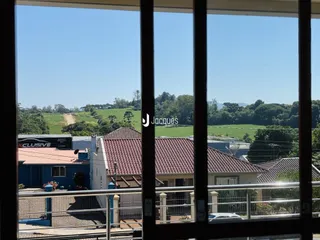Vista da fachada de uma residência com paisagem rural ao fundo.