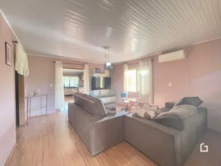 Sala de estar com sofá e piso de madeira clara.