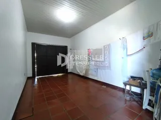 Vista interna de um corredor com piso de cerâmica vermelha.