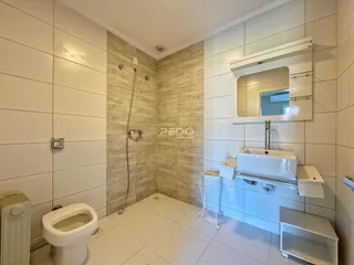 Foto de um banheiro com revestimento cerâmico e louças brancas.