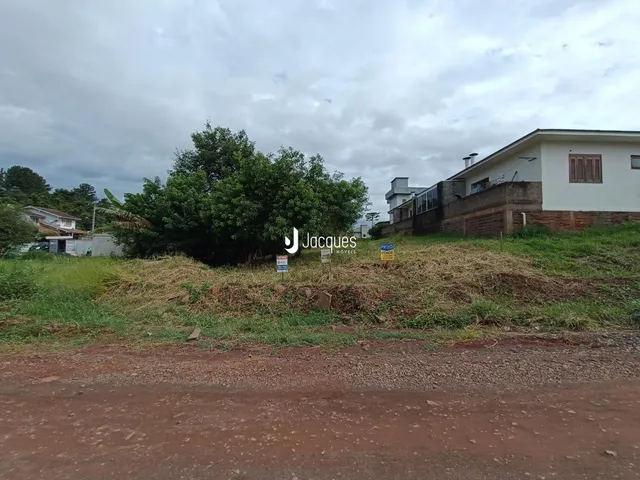 Vista externa de uma propriedade com vegetação e terreno no primeiro plano.