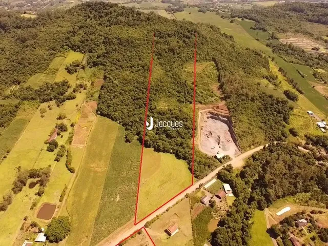 Vista aérea de uma propriedade rural com áreas de vegetação e campos.