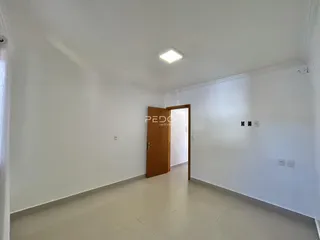Hall de entrada com paredes brancas e piso claro.
