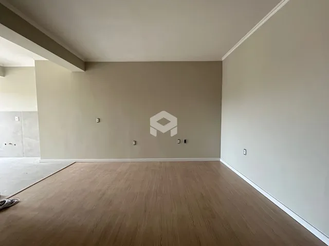 Espaço interno de uma residência com piso de madeira clara.