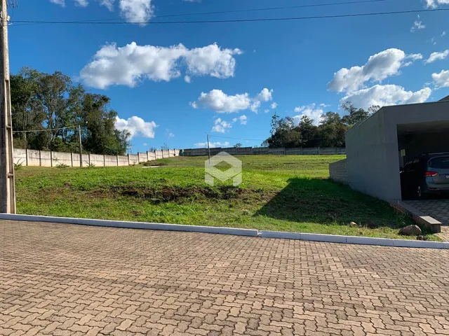 Vista externa de uma propriedade com um campo gramado e cerca.