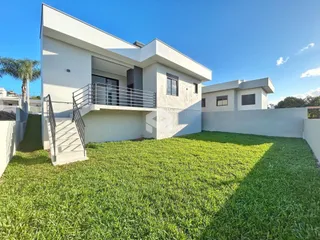 Fachada moderna de uma residência em Lajeado, Brasil, com jardim gramado.