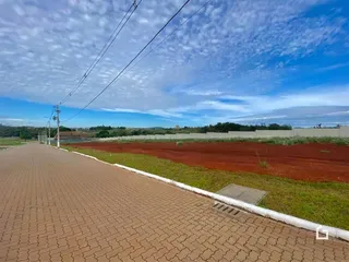 Vista da propriedade com cerca e campo aberto.
