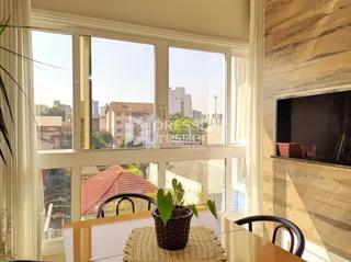 Sala de estar com grandes janelas que oferecem vista para a paisagem urbana.