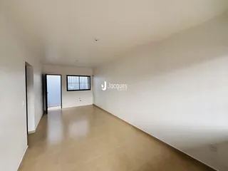 Vista interna de um ambiente amplo com piso claro e paredes brancas.