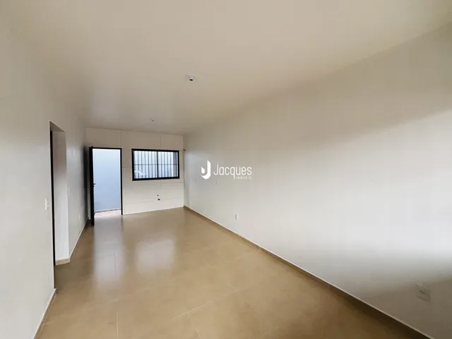 Vista interna de um ambiente amplo com piso claro e paredes brancas.