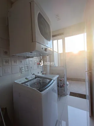 Foto de um interior com máquina de lavar roupa e paredes brancas.