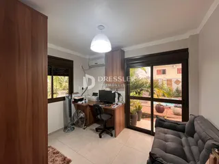 Interior de uma sala de estar com portas de vidro e móveis de madeira.