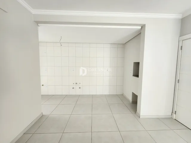 Interior de um ambiente com piso de cerâmica e paredes brancas.