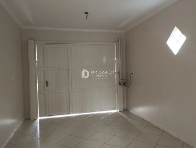 Interior de um cômodo com porta branca e piso de cerâmica.