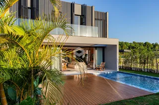 Vista da fachada de uma residência com piscina e deck em Lajeado.