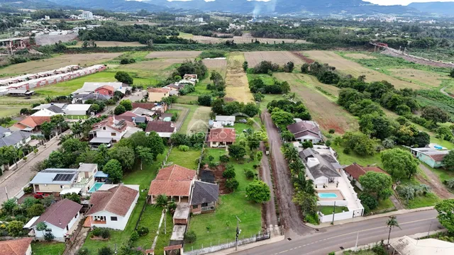 Vista aérea de uma área residencial com casas e terrenos verdes em Lajeado.