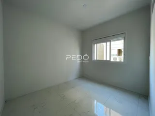 A sala de estar apresenta paredes brancas e piso de mármore claro.