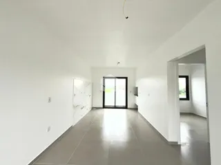 Corredor branco com parede de mármore na entrada da residência.
