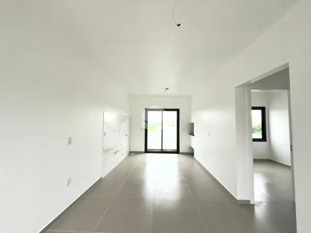 Corredor branco com parede de mármore na entrada da residência.