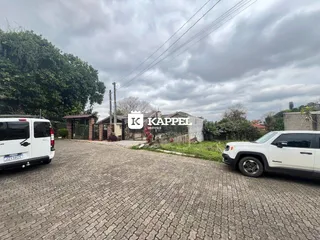 Vista externa da propriedade em Lajeado, com veículos estacionados na frente.