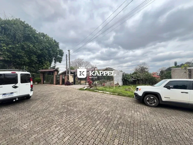 Vista externa da propriedade em Lajeado, com veículos estacionados na frente.