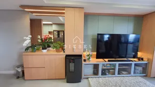 Sala de estar com armários de madeira e televisão instalada.