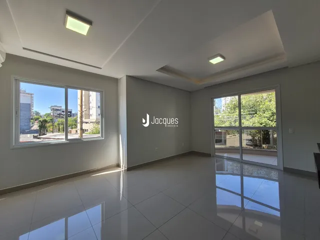 Sala de estar com grandes janelas iluminadas em um imóvel em Lajeado.