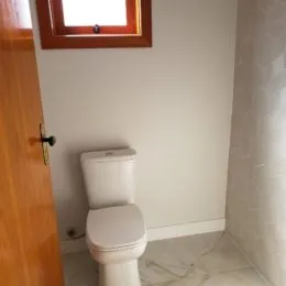 Foto de um banheiro mostrando um vaso sanitário branco.