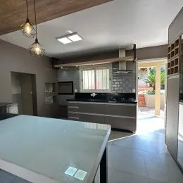 Vista de uma bancada de cozinha moderna com armários na área interna do imóvel.