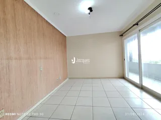 Ambiente interno de uma sala com piso de cerâmica clara e grandes janelas.