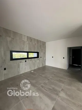 Ambiente interno com parede de concreto aparente e piso de cerâmica.