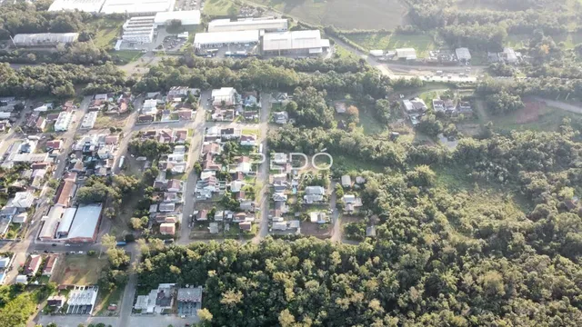 Vista aérea de uma área residencial em Lajeado, Brasil, mostrando casas e vegetação.