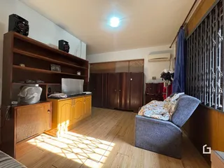 A sala de estar apresenta piso de madeira e móveis de madeira.