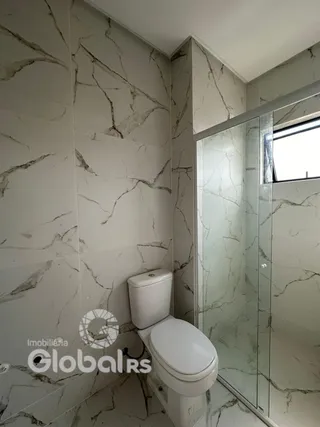 Foto de um banheiro com revestimento de mármore nas paredes.
