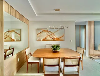 Sala de jantar com mesa de madeira e cadeiras em um ambiente claro.