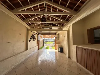 Corredor interno com teto de madeira exposta e piso de cerâmica.