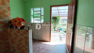 Interior de uma sala com parede de tijolos aparentes e porta de vidro abrindo para o jardim.