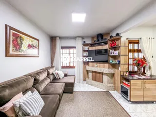 Sala de estar com sofá e painel de madeira na residência.