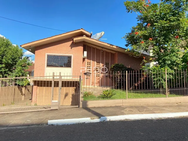 Fachada de casa de tijolos com cerca e portão de ferro na Lajeado.