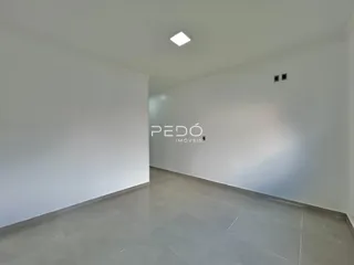 Hall de entrada com piso de cerâmica clara e paredes brancas.