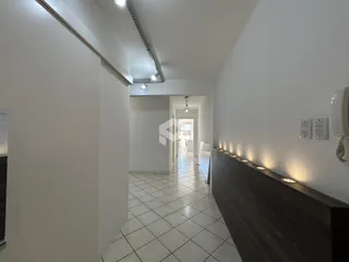 Corredor interno de uma residência com piso de cerâmica e paredes brancas.