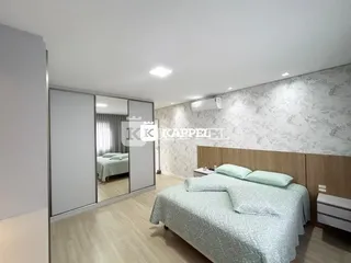 Quarto com cama e armários em um imóvel com piso de madeira clara.