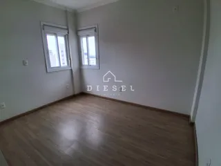 Ambiente interno com piso de madeira e duas janelas.