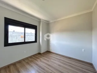 Uma sala de estar com piso de madeira e janela.
