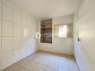 Corredor interno com piso e paredes revestidos de cerâmica.